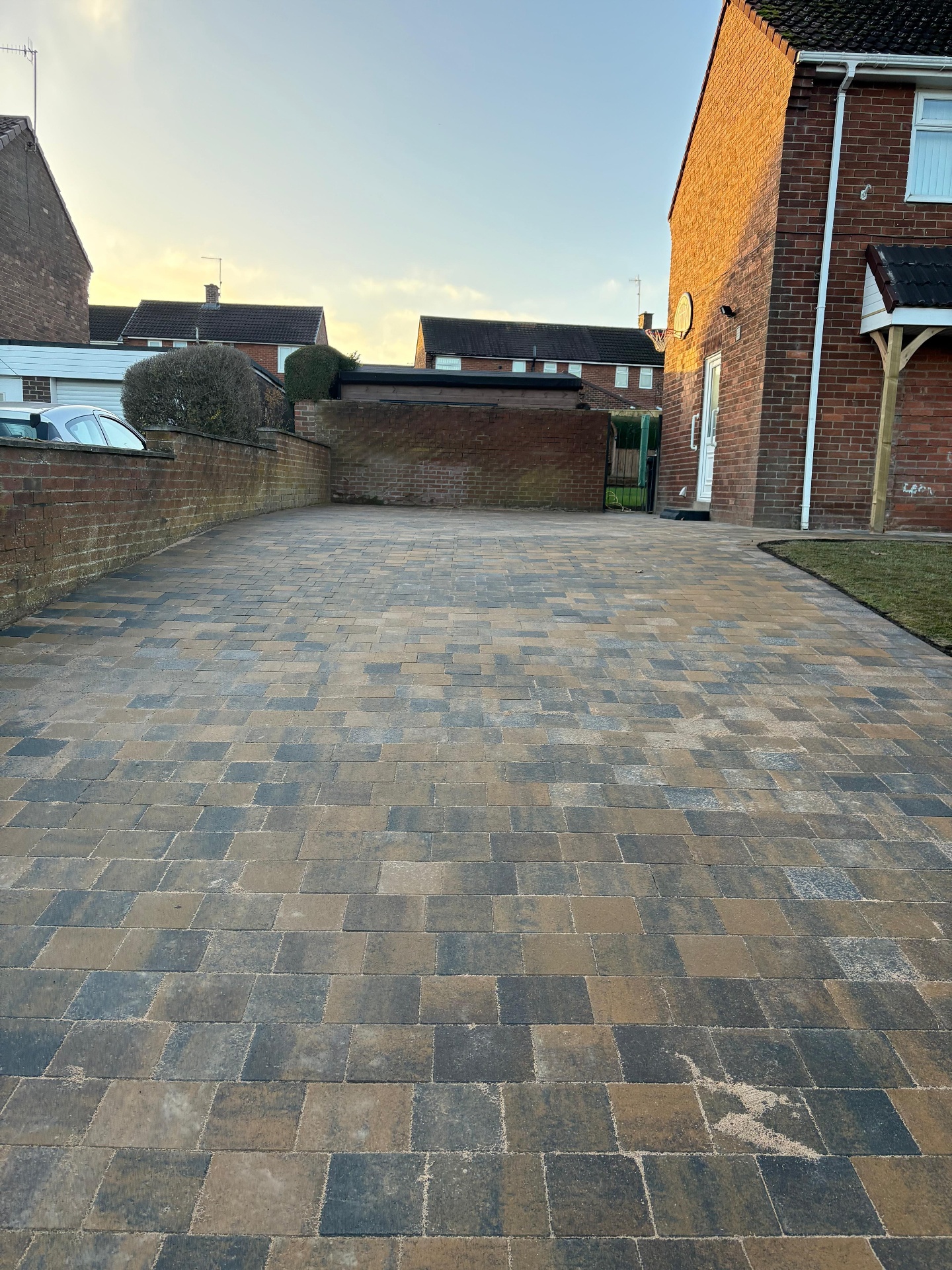 Block paved driveway installed with a mixed-tone finish outside a brick home